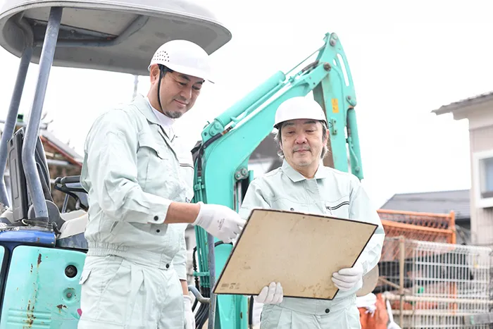 現場で作業する親方と新人スタッフ
